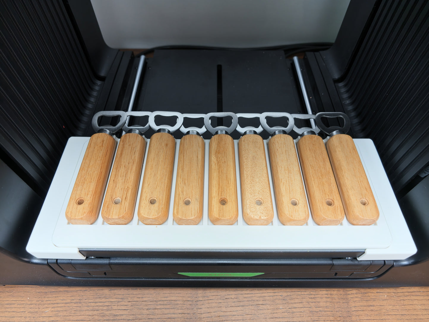 Wooden bottle opener jig for xTool O1 Omni UV printer holding 9 bottle openers