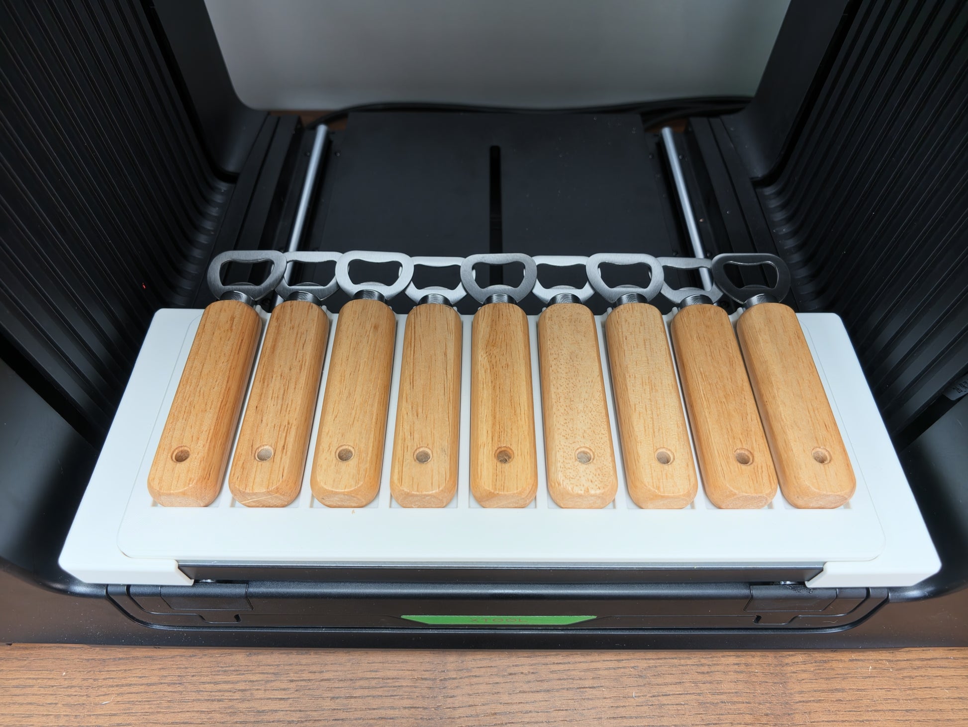 Wooden bottle opener jig for xTool O1 Omni UV printer holding 9 bottle openers