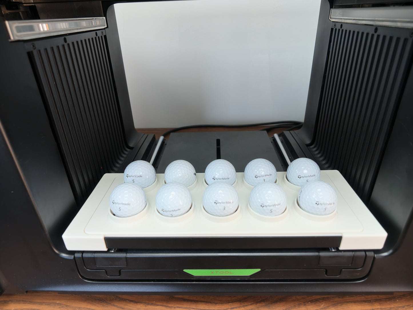 Matte white 3D printed golf ball jig for the xTool O1 Omni UV printer