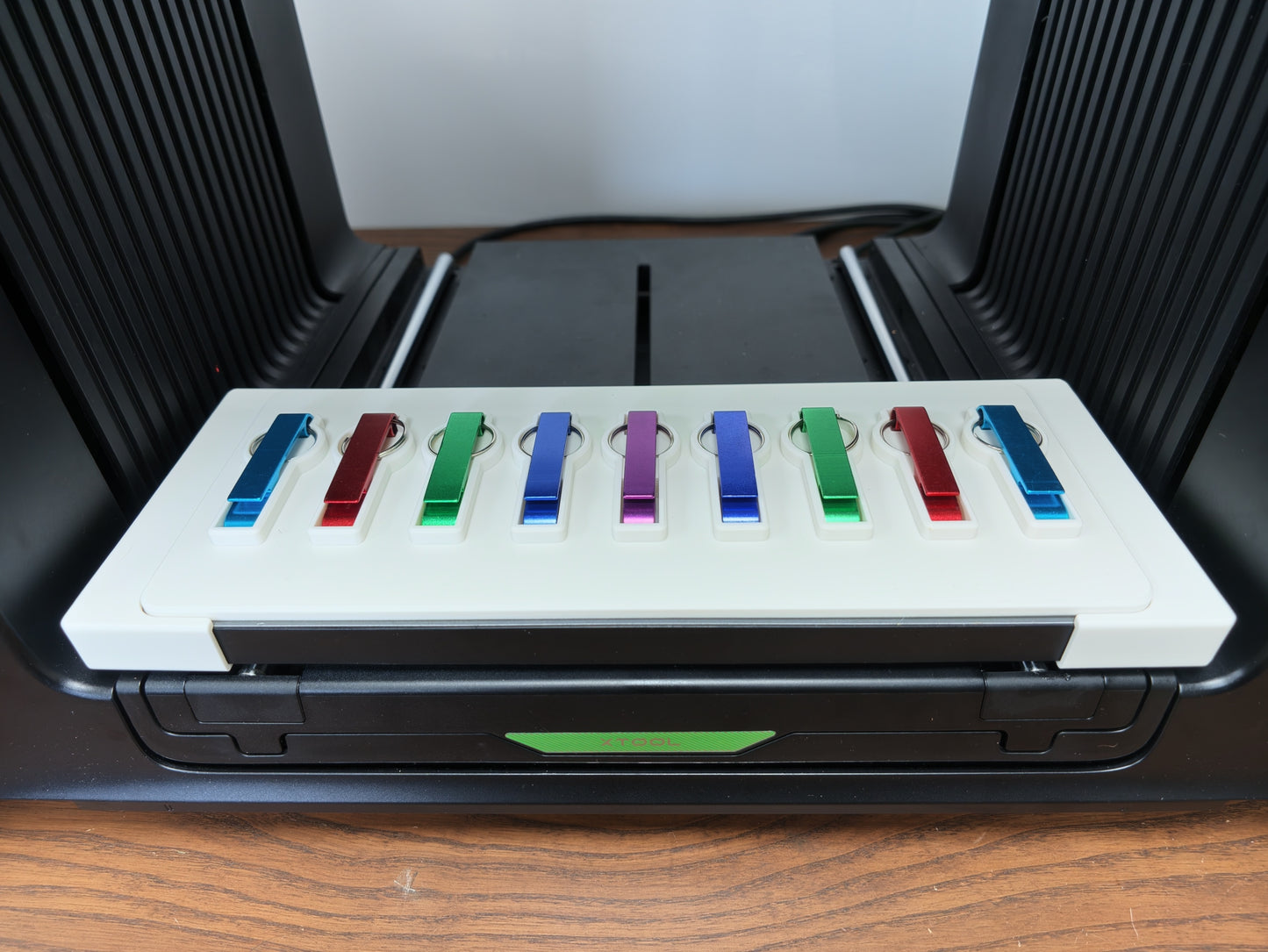 Matte white 3D printed bottle opener keychain jig for the xTool O1 Omni