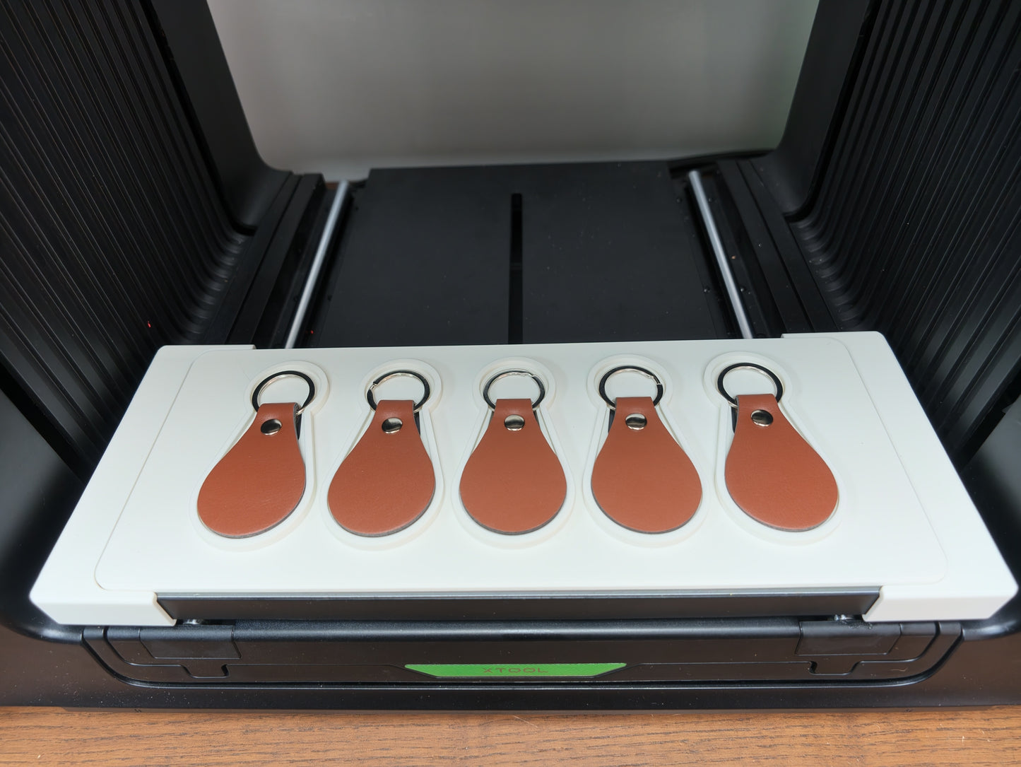 Matte white 3D printed leather keychain jig for the xTool O1 Omni