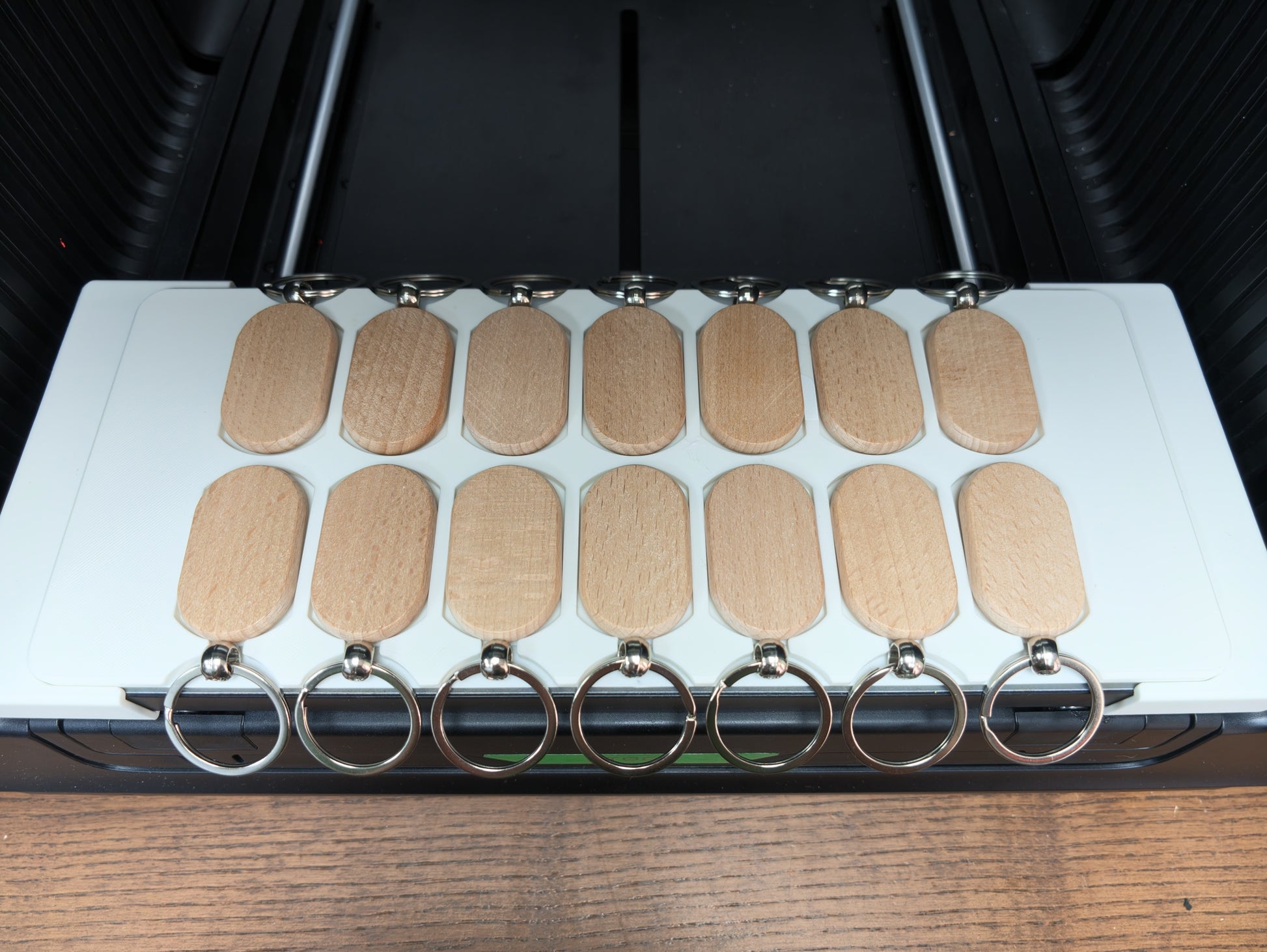Matte white 3D printed oval wooden keychain jig for the xTool O1 Omni