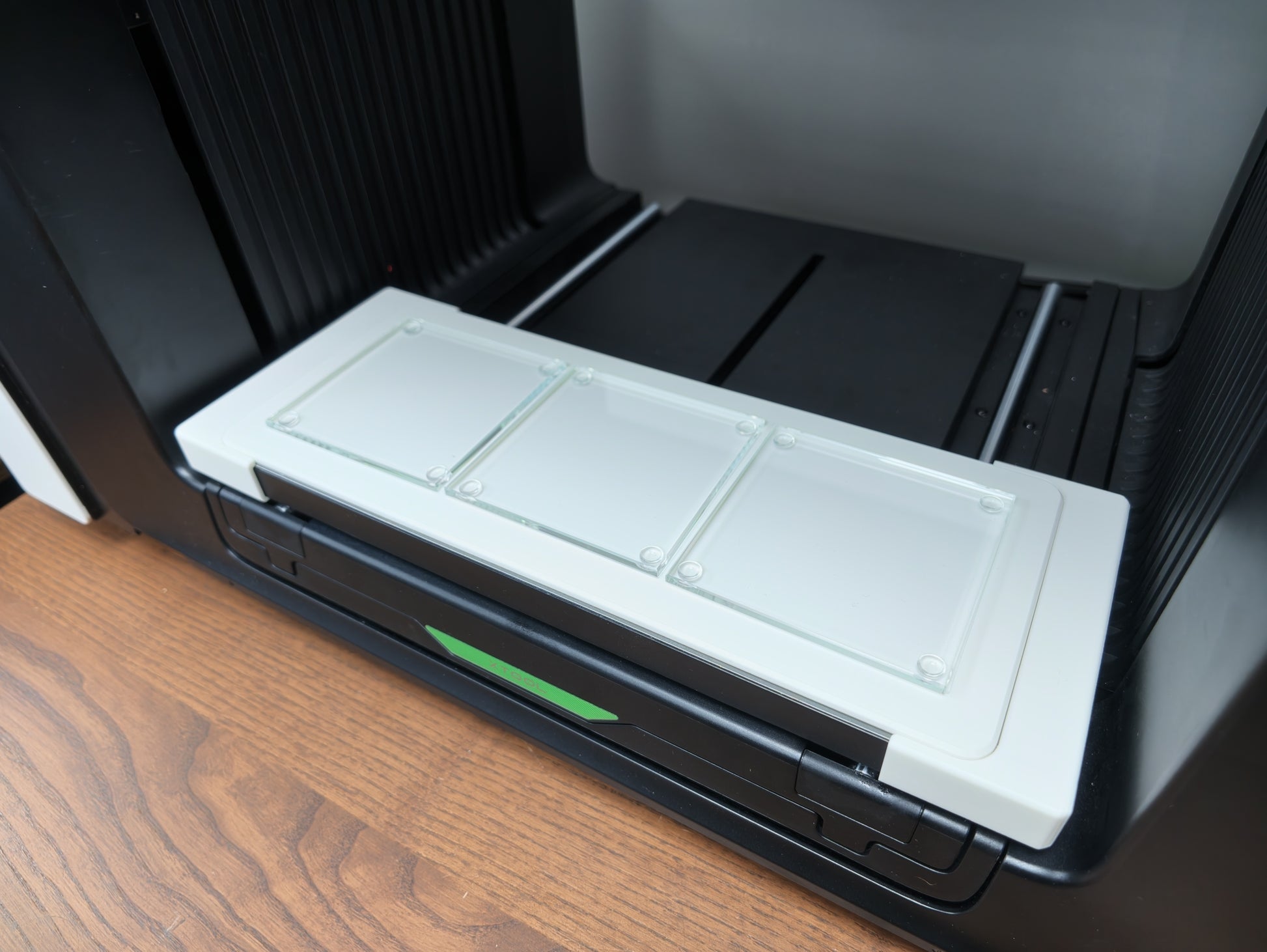 Close-up of glass coasters seated in the L3D jig on the xTool O1 Omni bed