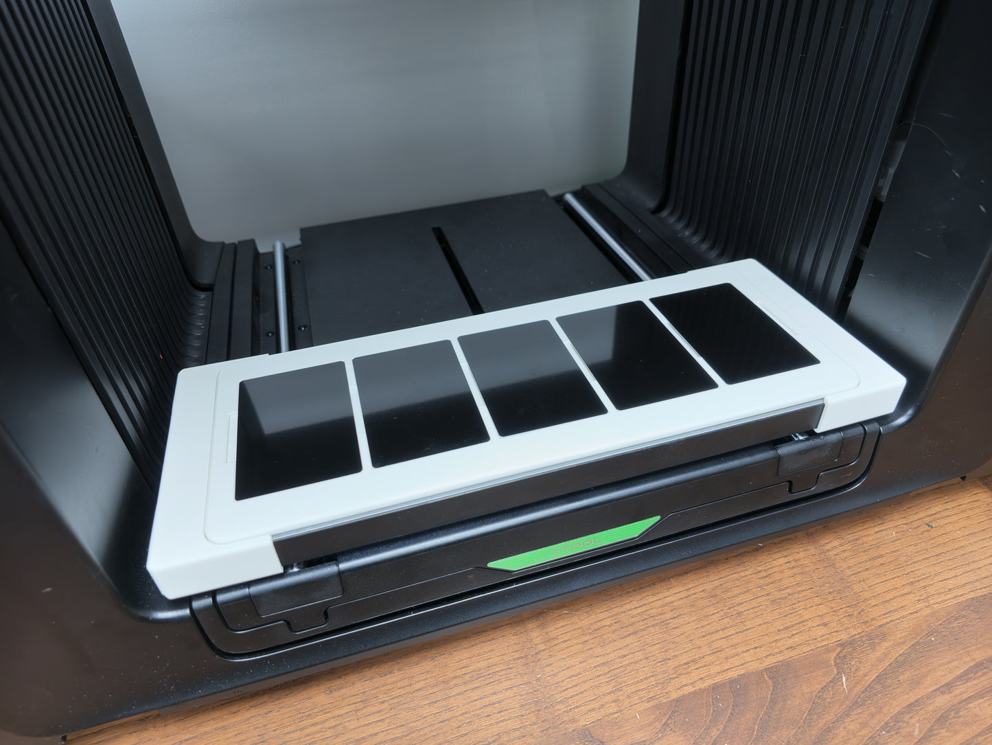 Close-up of metal business cards seated in the L3D jig on the xTool O1 Omni bed