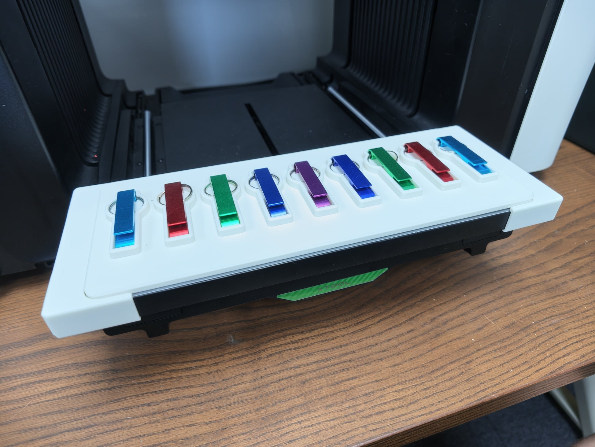 Metal bottle opener keychain jig installed in the Omni Bracket System on an xTool O1 Omni