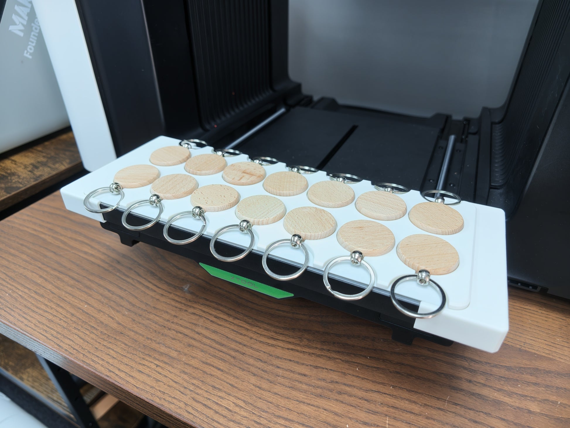 Round wooden keychain blanks positioned in the jig for the xTool O1 Omni